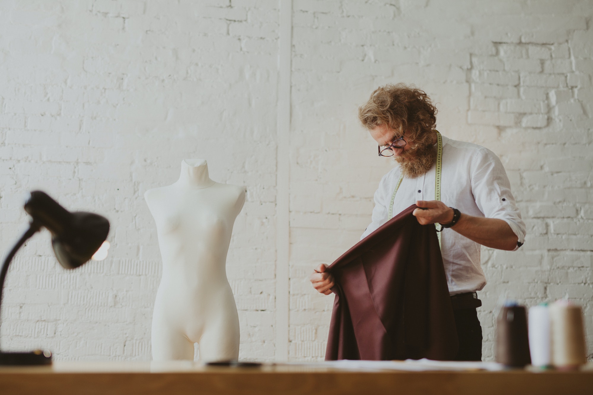 tailor-looking-at-piece-of-fabric